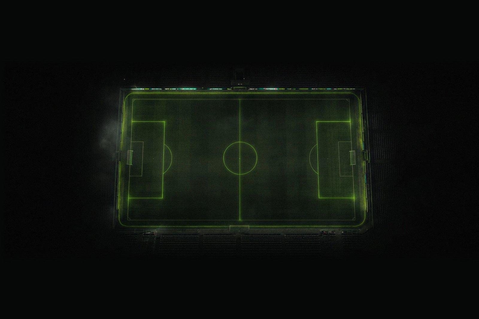 Vue aérienne d’un terrain de football de nuit aux lignes vert fluo