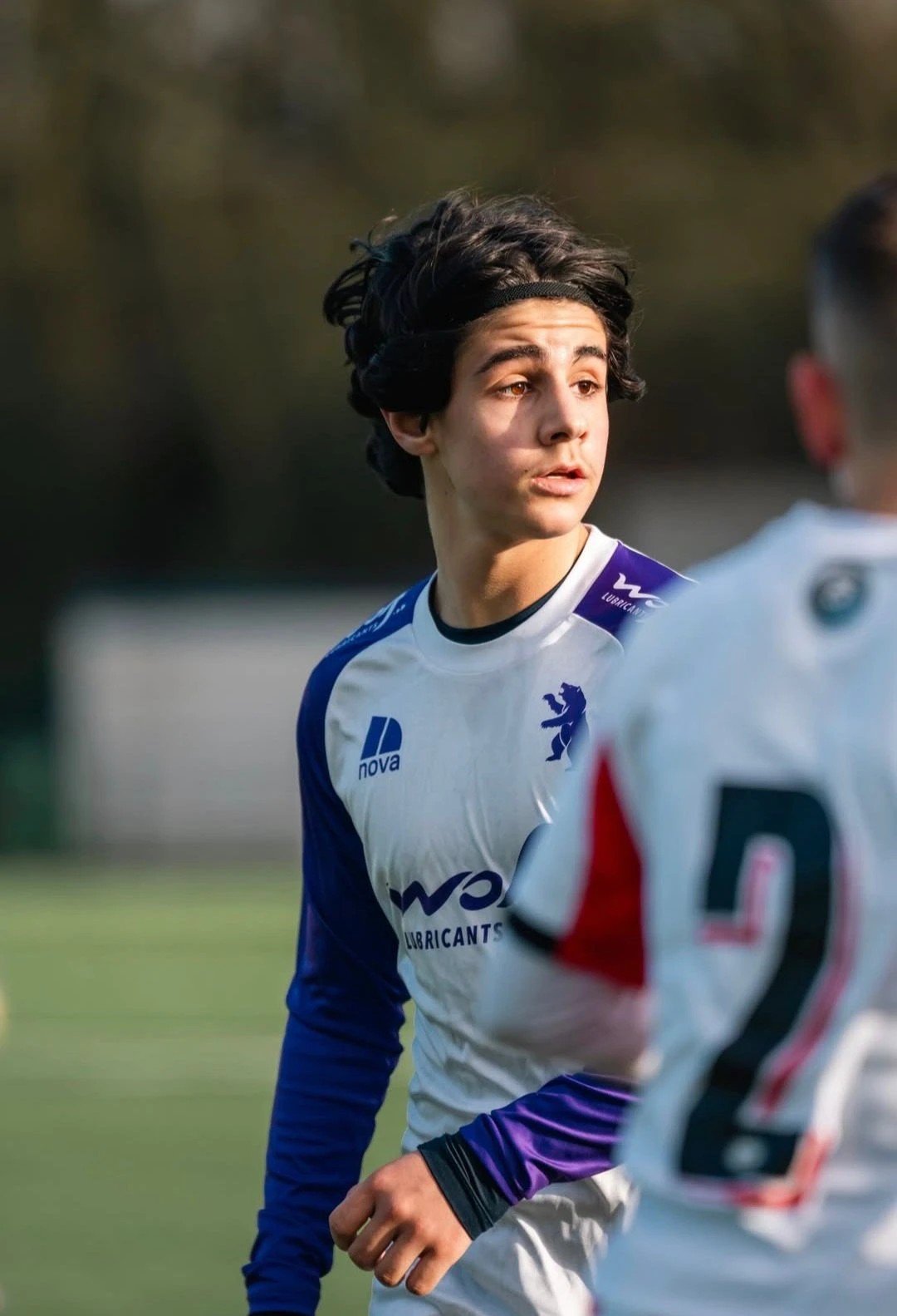 David Elias en match, bandeau dans les cheveux, maillot blanc et violet du Beerschot