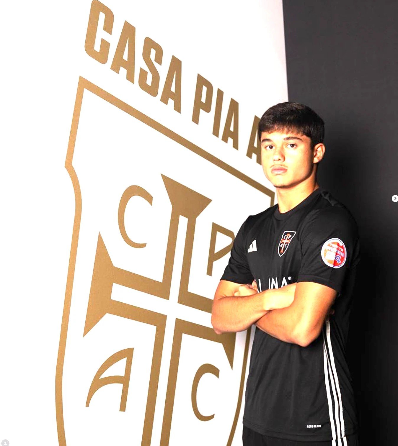 Lucca Ayala pose devant le blason du Casa Pia AC