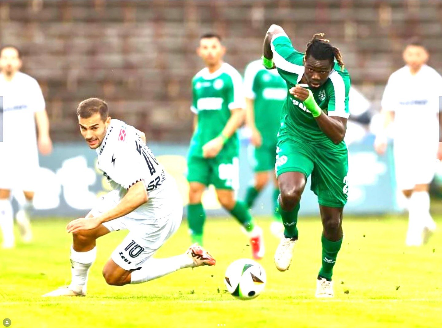 Joueur en vert lancé à pleine vitesse devant un adversaire en blanc