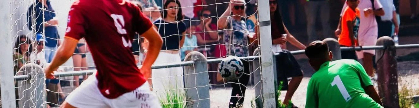 Frappe au but face au gardien, devant des spectateurs massés derrière le filet