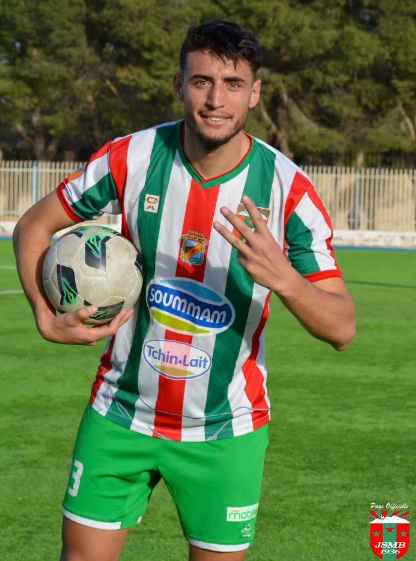 Rayane Gacem sourit, ballon sous le bras, sous le maillot de la JSM Béjaïa