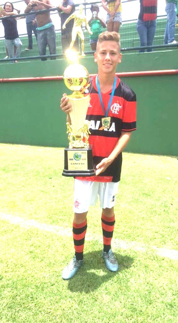 Zé Thiago, jeune, pose avec le trophée de champion sous le maillot de Flamengo
