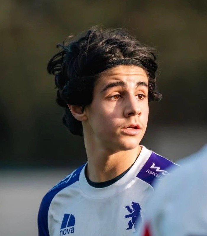 Portrait de David Elias en match, bandeau dans les cheveux, maillot blanc et violet du Beerschot